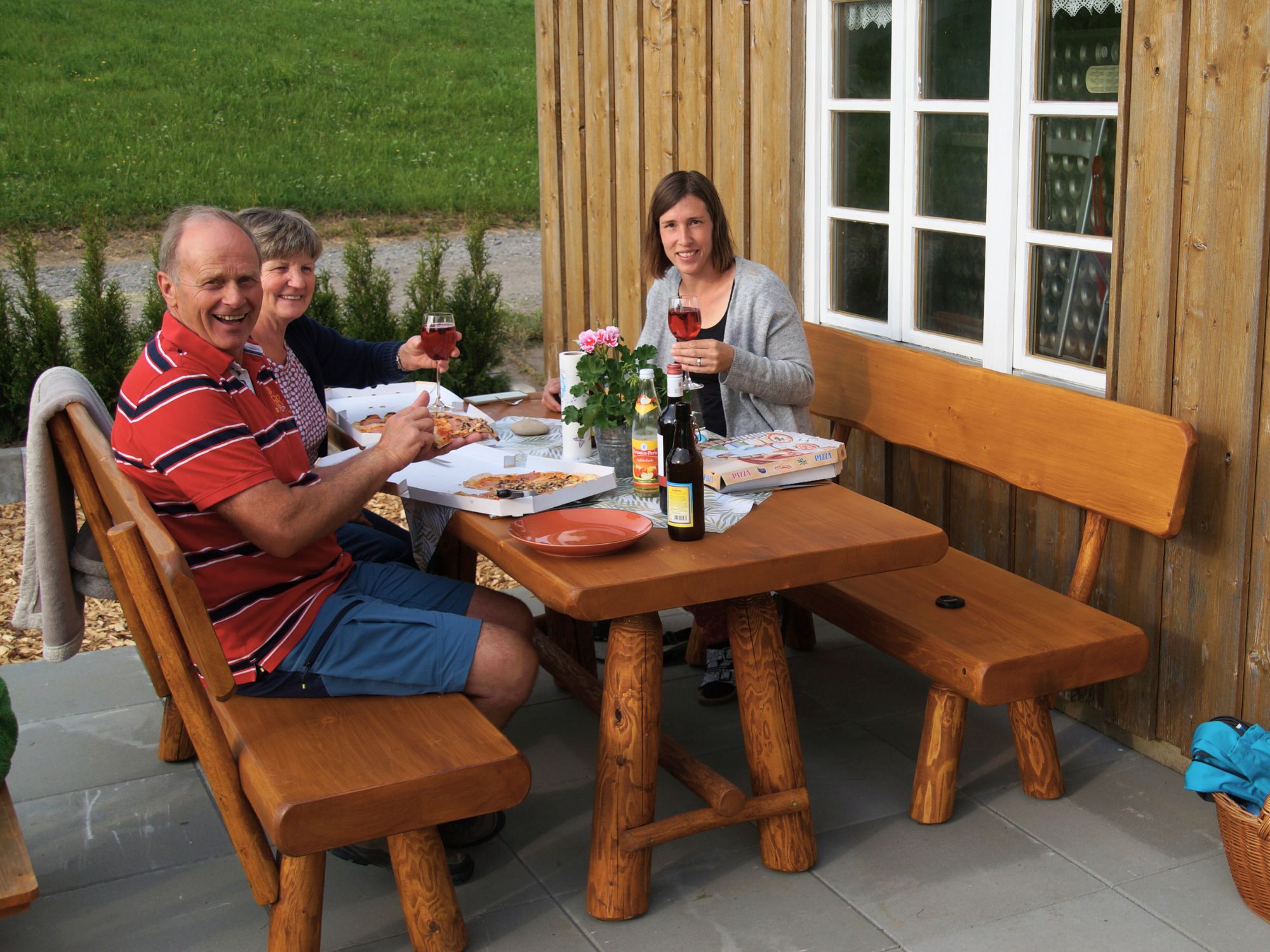Gäste genießen einen gemütlichen Abend mit Brotzeit und Wein auf der Terrasse des Ferienhofs Eger in Immenstadt im Allgäu