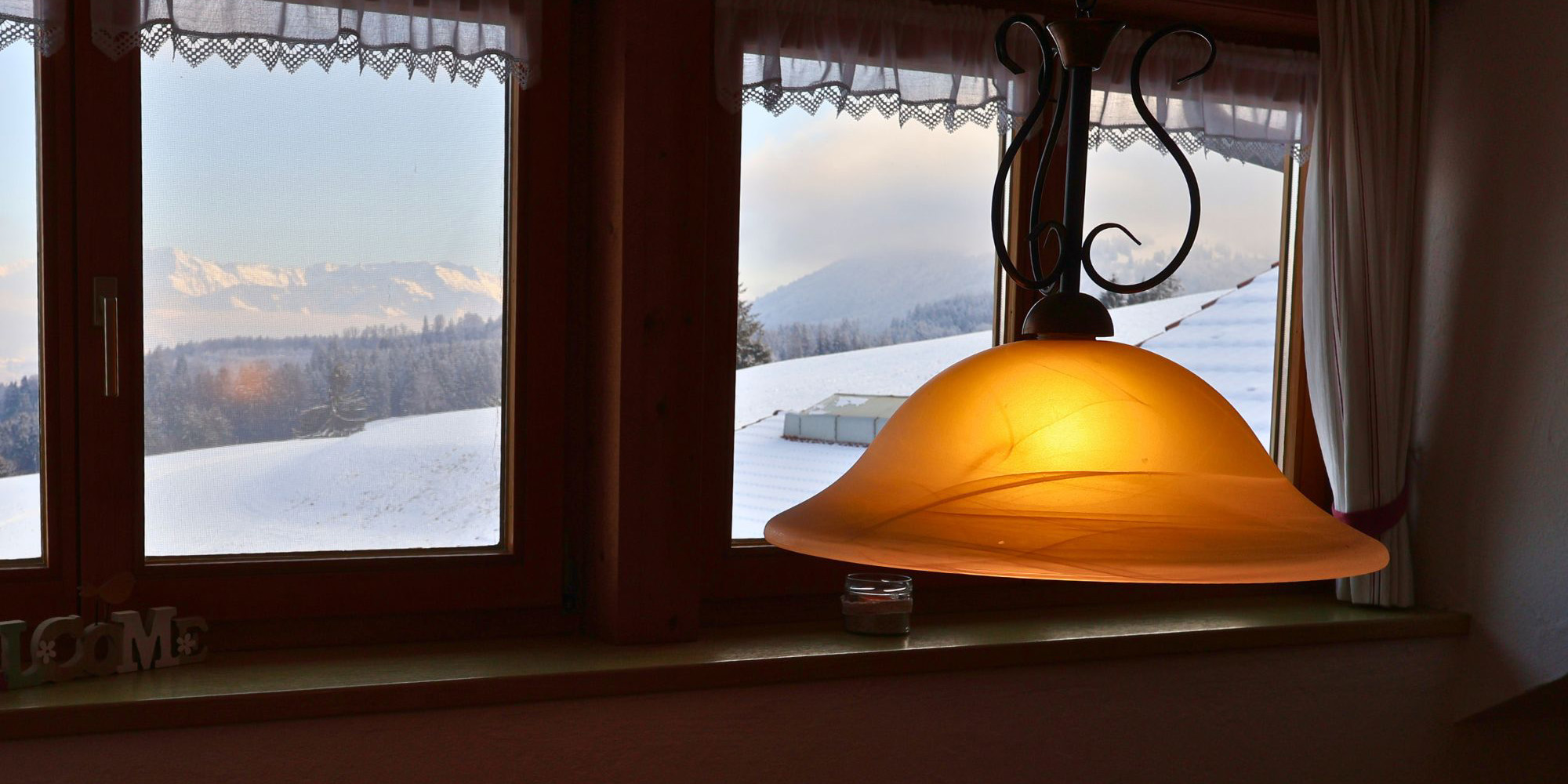 Winterlicher Ausblick aus der Ferienwohnung Grüntenblick im Allgäu – verschneite Landschaft und gemütliche Stimmung mit Blick auf die Alpen