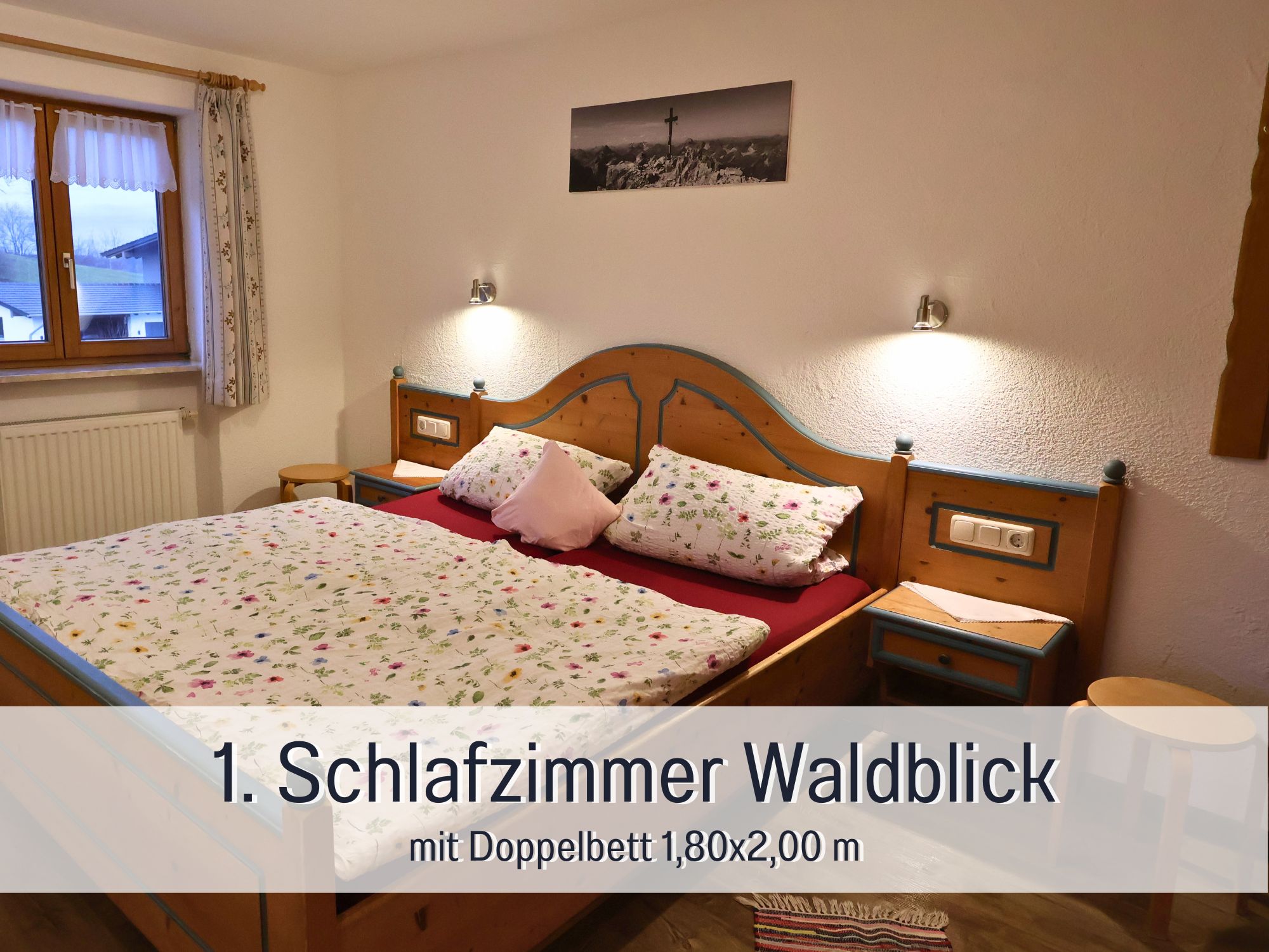 Erstes Schlafzimmer der Ferienwohnung Waldblick mit Doppelbett, Leselampen und Fensterblick – ideal für Eltern im Allgäu-Urlaub