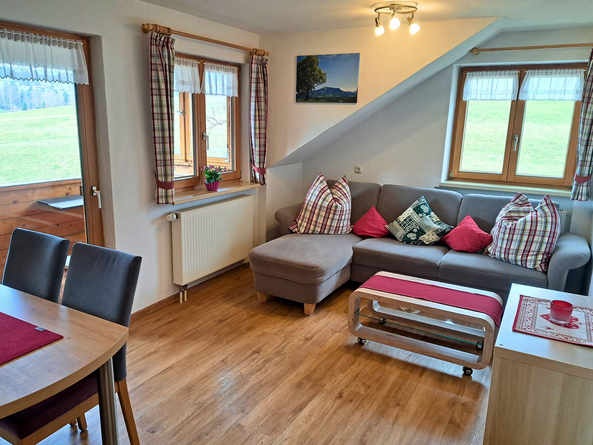 Heller Wohn- und Essbereich der Ferienwohnung Waldblick mit Sofa, Esstisch und Naturblick – ideal für Familienurlaub im Allgäu