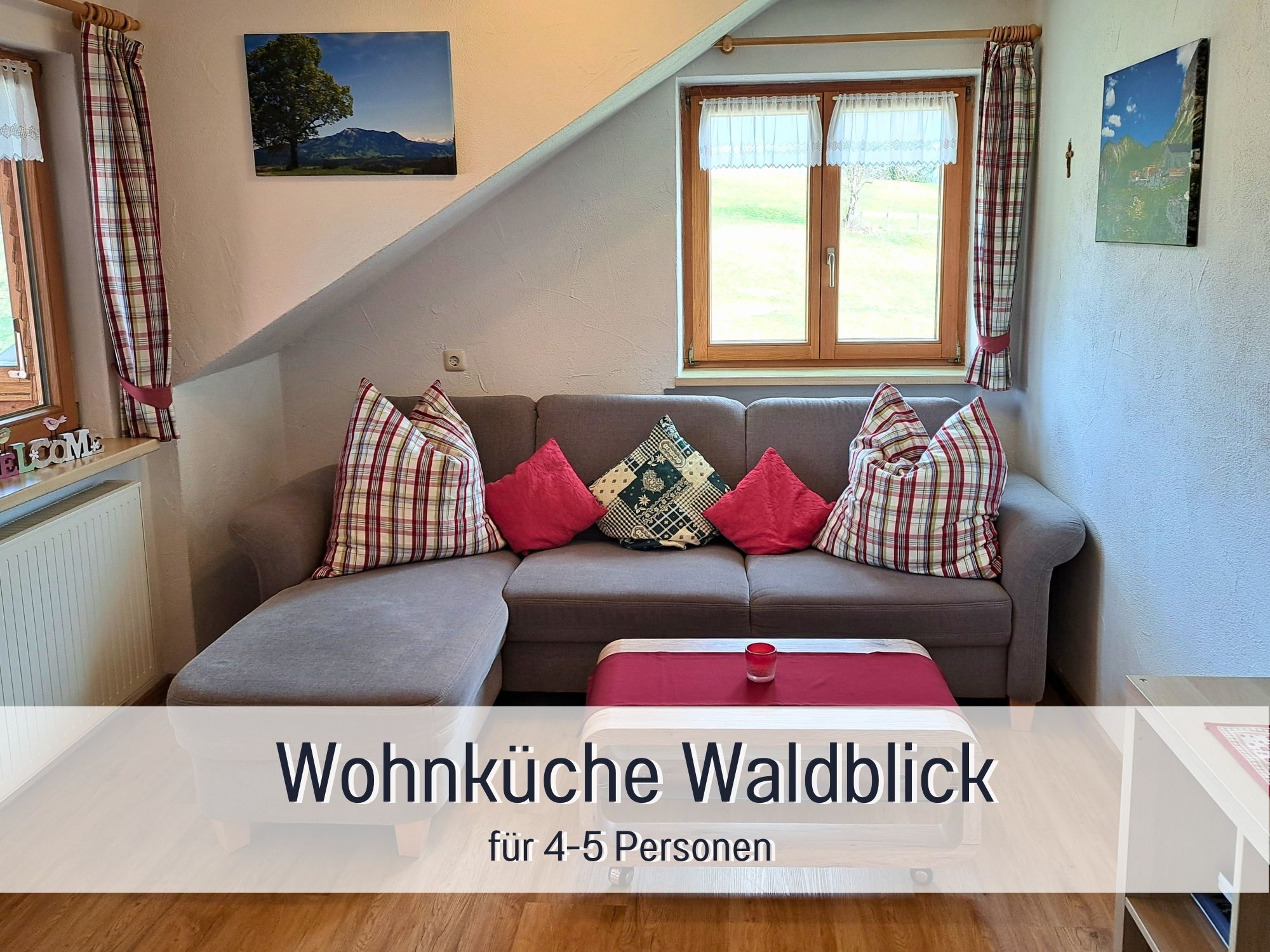 Gemütliches Wohnzimmer der Ferienwohnung Waldblick mit Sofa, Kissen & Fensterblick – ideal für Familienurlaub im Allgäu